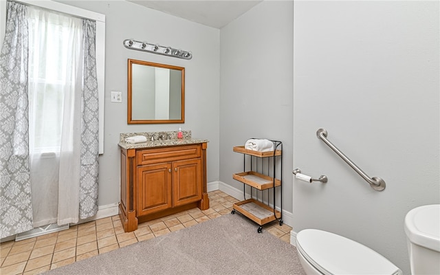 bathroom featuring a shower with shower curtain, vanity, toilet, and tile patterned floors