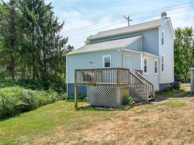 back of property featuring central AC, a deck, and a lawn