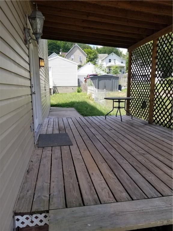 wooden terrace with an outbuilding and a lawn