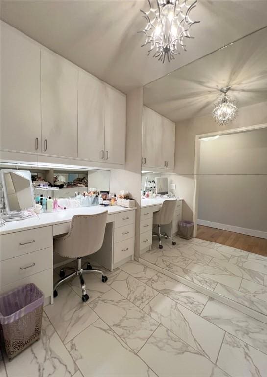 office with a chandelier, marble finish floor, and built in study area