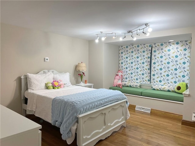 bedroom featuring visible vents and wood finished floors