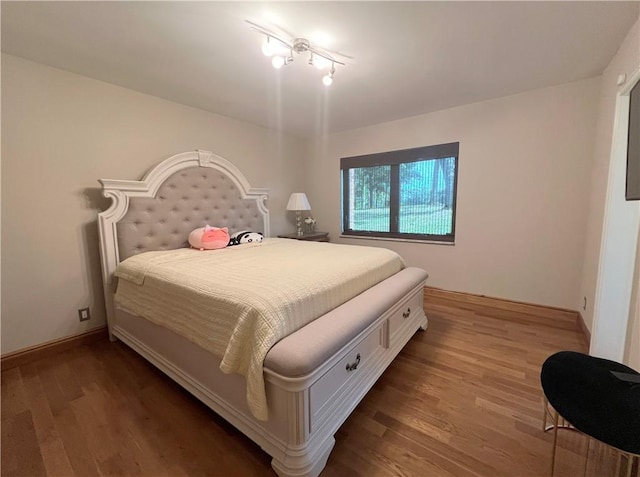 bedroom with baseboards and wood finished floors