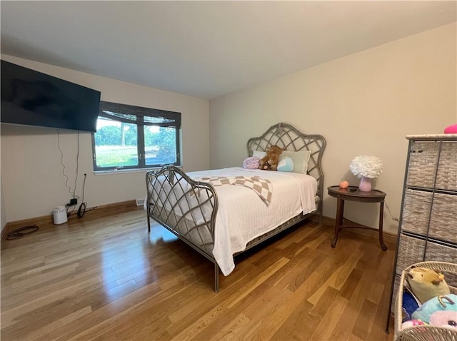 bedroom featuring baseboards and wood finished floors