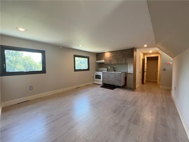 unfurnished living room with light wood-type flooring, baseboards, and recessed lighting