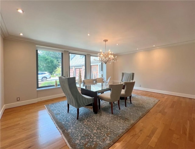 dining room with a chandelier, baseboards, ornamental molding, and light wood finished floors