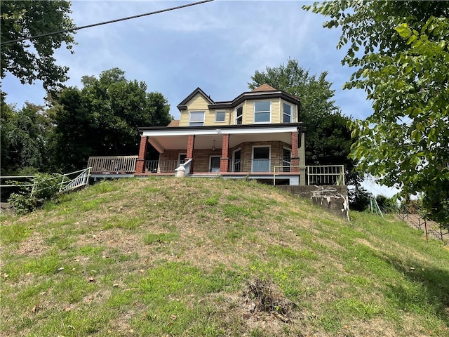 rear view of property with a porch and a yard