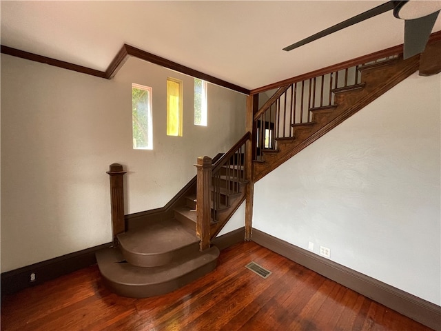 staircase featuring ornamental molding and wood-type flooring