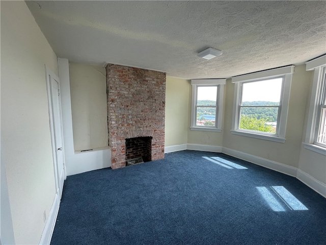 unfurnished living room featuring a textured ceiling, carpet floors, a fireplace, and brick wall