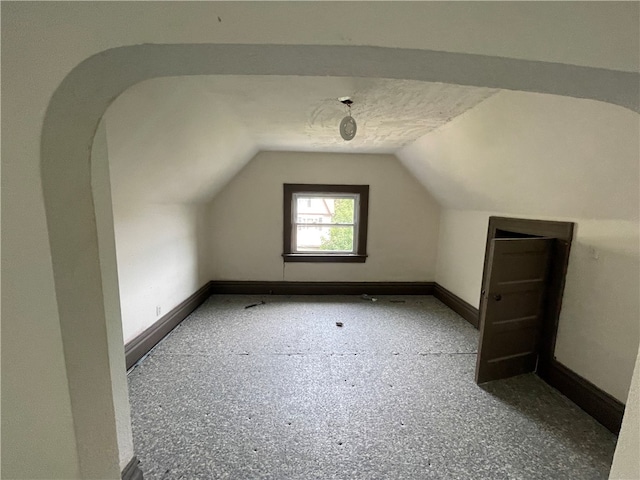 additional living space featuring lofted ceiling