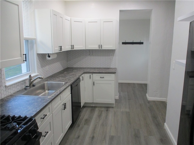 kitchen with white cabinets, black appliances, sink, and backsplash