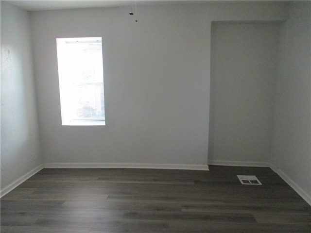 empty room with dark hardwood / wood-style flooring