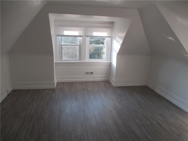 bonus room with dark wood-type flooring and vaulted ceiling