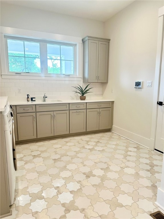 kitchen with sink, a healthy amount of sunlight, and tasteful backsplash