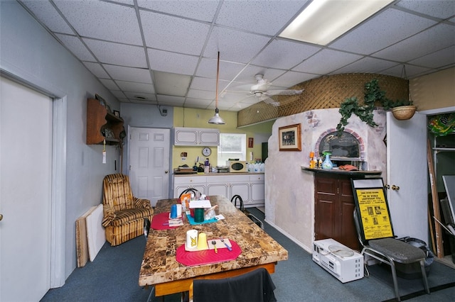 interior space featuring ceiling fan, carpet floors, and a paneled ceiling