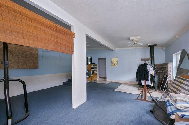 145 Short Ridge Rd, Coal Center Boro, PA 15423 - interior space with carpet flooring, a wood stove, a ceiling fan, a textured ceiling, and crown molding