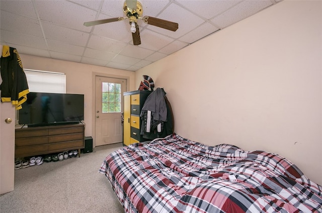 carpeted bedroom featuring a drop ceiling and ceiling fan