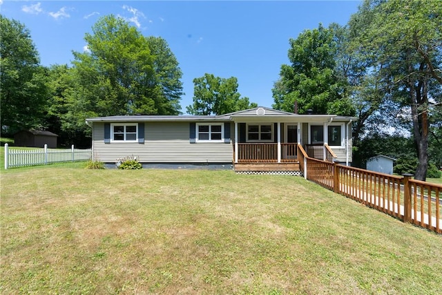 view of front of property featuring a storage shed, fence, an outbuilding, and a front yard