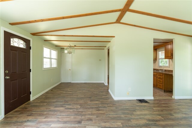 entrance foyer featuring lofted ceiling, wood-type flooring, a notable chandelier, and sink