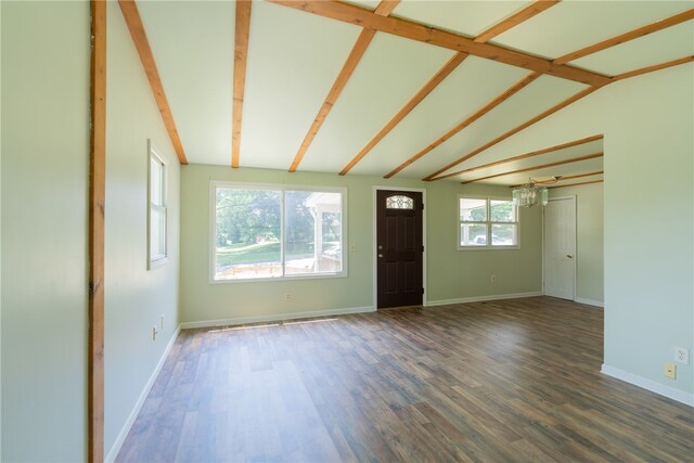 unfurnished living room with wood-type flooring, lofted ceiling with beams, and plenty of natural light