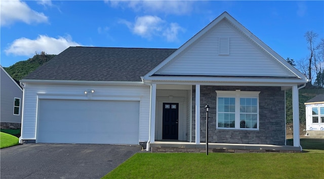 view of front facade featuring a shingled roof, stone siding, aphalt driveway, an attached garage, and a front yard