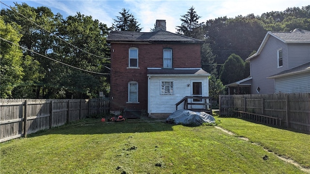 rear view of property featuring a lawn