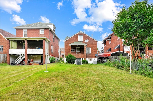 back of property featuring cooling unit and a yard