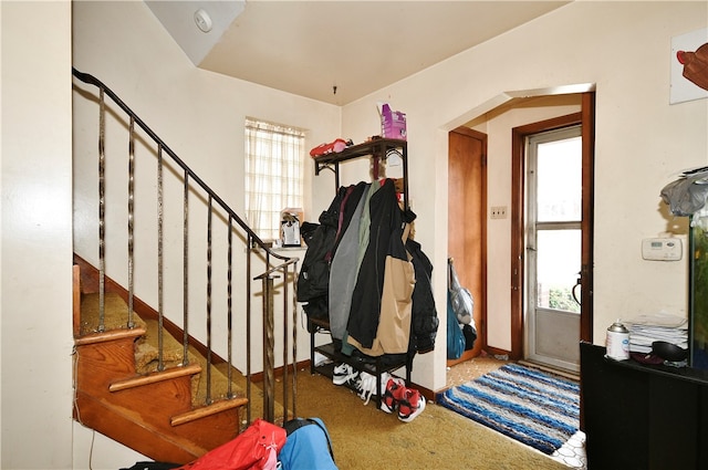 carpeted entryway featuring vaulted ceiling