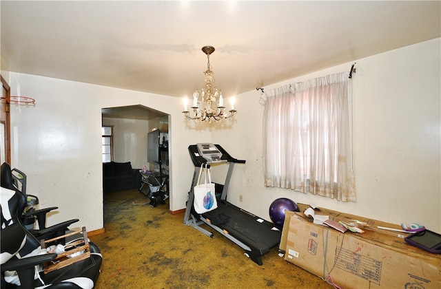 workout room featuring carpet floors and a chandelier