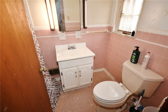 bathroom featuring vanity, tile walls, toilet, and tile patterned floors