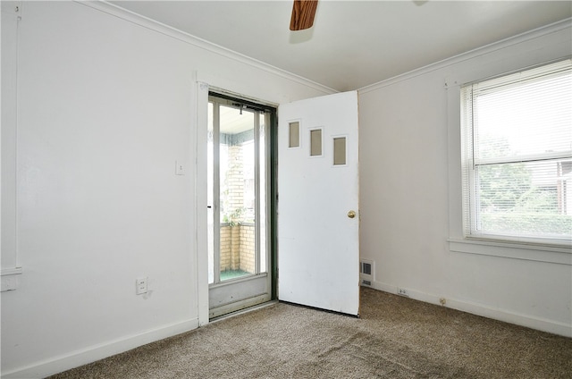 carpeted empty room featuring ceiling fan and crown molding