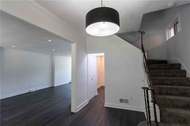 staircase featuring wood-type flooring and ornamental molding