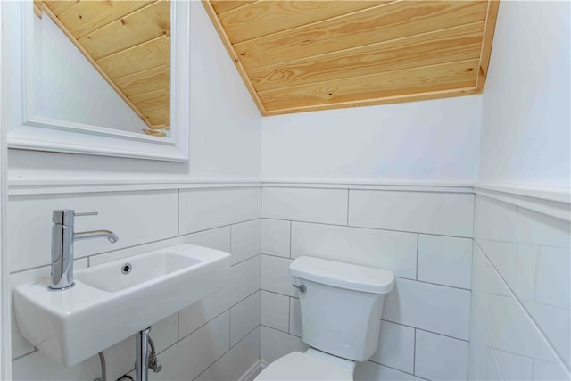 bathroom featuring tile walls, lofted ceiling, toilet, and wooden ceiling