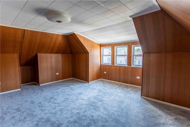 bonus room featuring lofted ceiling, wood walls, and carpet floors