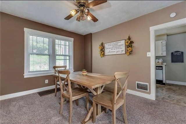 carpeted dining space with baseboards, visible vents, and a ceiling fan