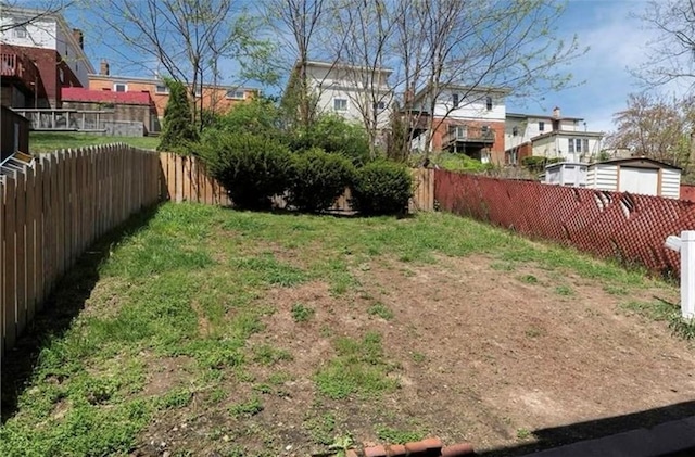 view of yard featuring a fenced backyard and a residential view