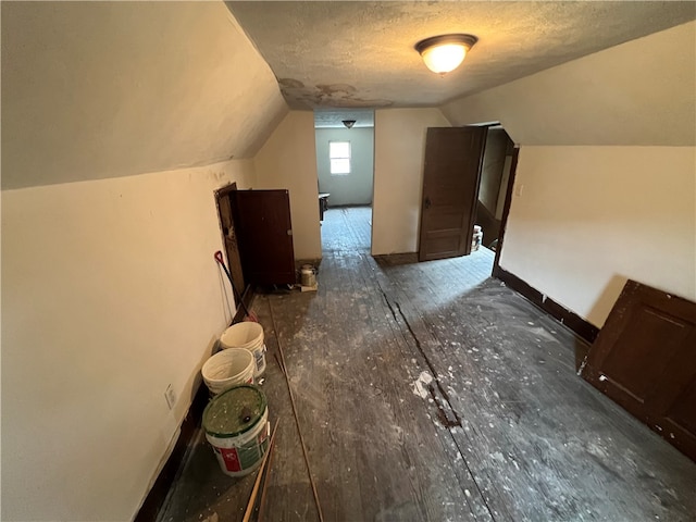 bonus room featuring lofted ceiling and a textured ceiling