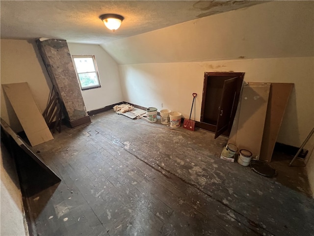 additional living space featuring lofted ceiling and a textured ceiling