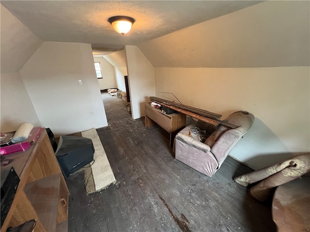 bonus room with lofted ceiling, dark hardwood / wood-style flooring, and a textured ceiling