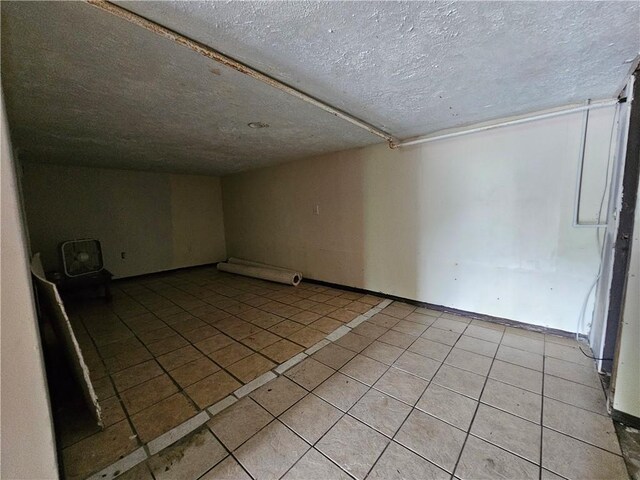 bonus room featuring light tile patterned flooring and a textured ceiling