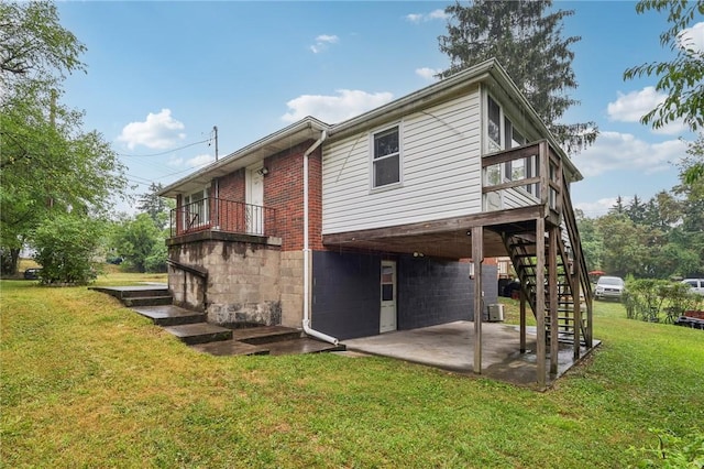 rear view of property featuring central air condition unit, a yard, and a patio area