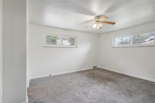 carpeted spare room featuring ceiling fan