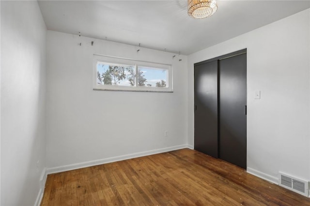 unfurnished bedroom featuring a closet and hardwood / wood-style floors