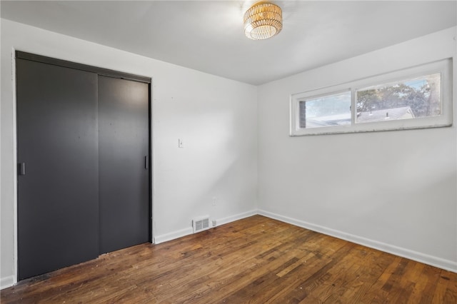 unfurnished bedroom featuring a closet and hardwood / wood-style flooring