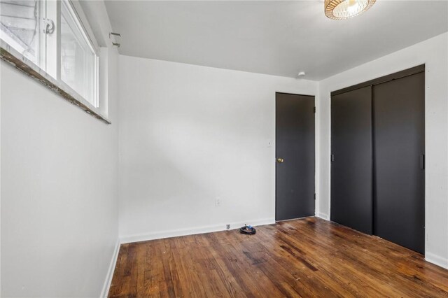 unfurnished bedroom with a closet and hardwood / wood-style flooring