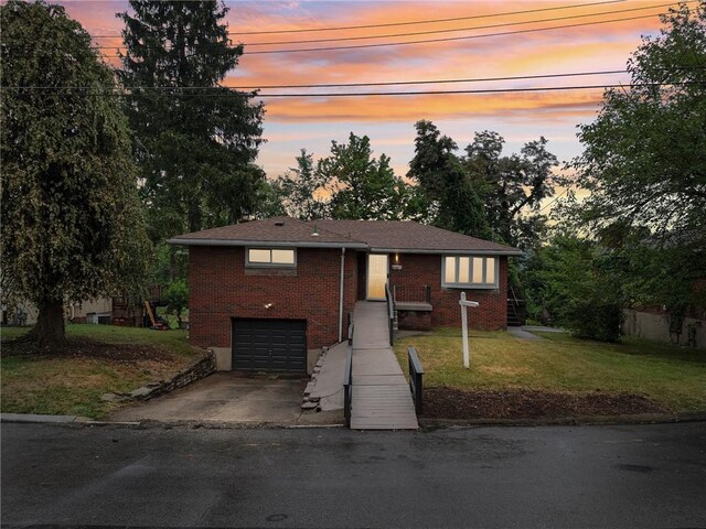 view of front of house with a garage and a yard