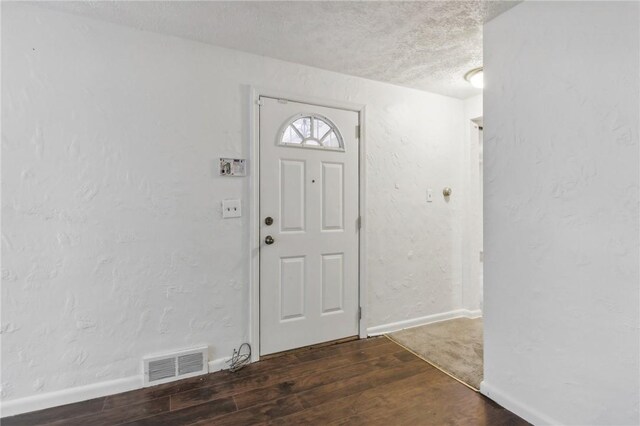 foyer with wood-type flooring and a textured ceiling