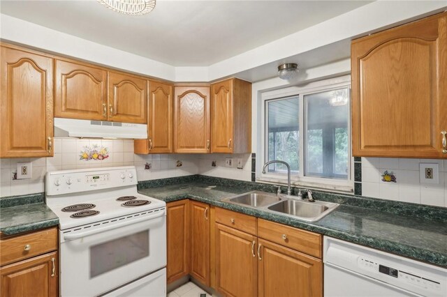 kitchen with sink, white appliances, and backsplash