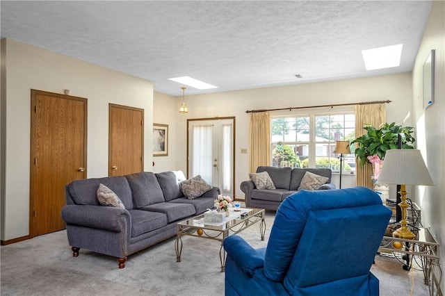 living room with a skylight, french doors, a textured ceiling, and carpet