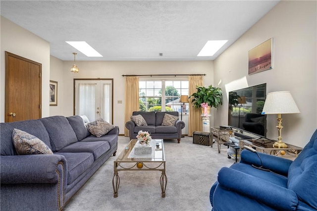 carpeted living room with a textured ceiling and a skylight