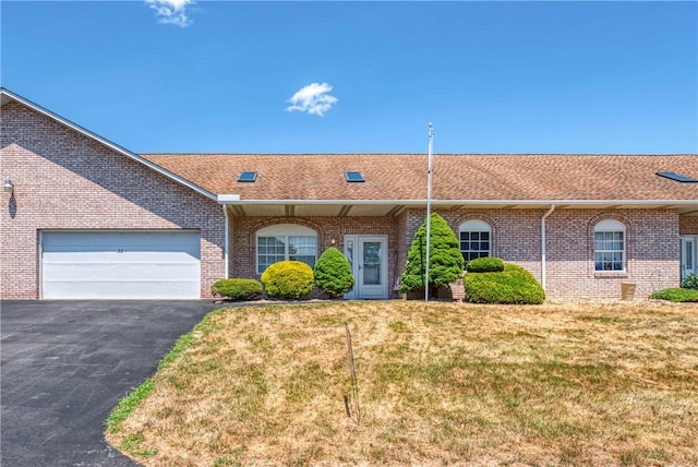 ranch-style house with a garage and a front lawn